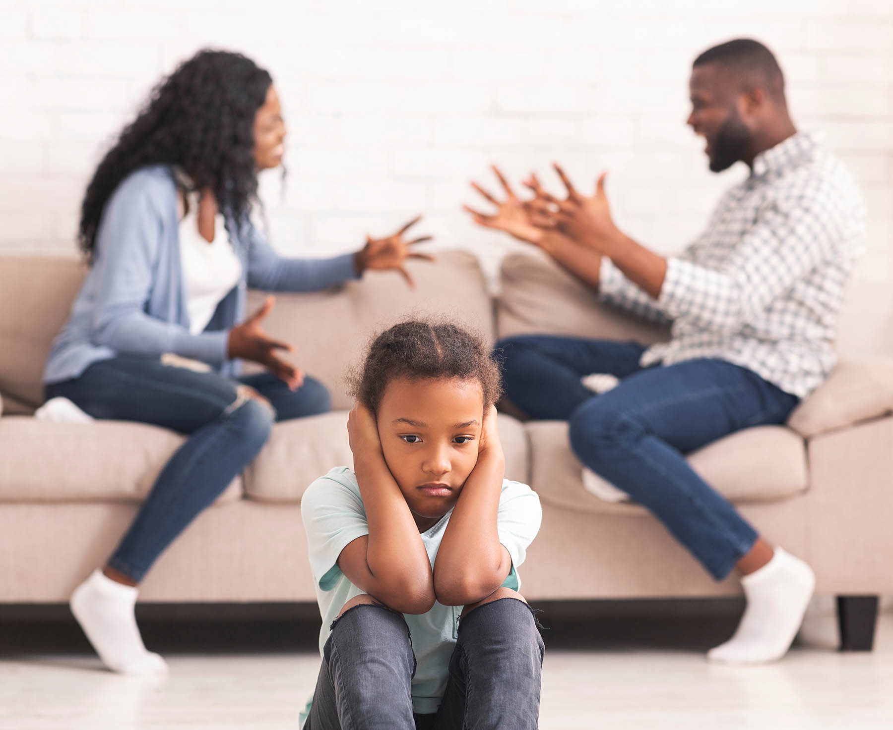 Children and divorce concept. Upset african girl closing ears not to listen parents arguing, sitting on floor at home, feeling lonely.