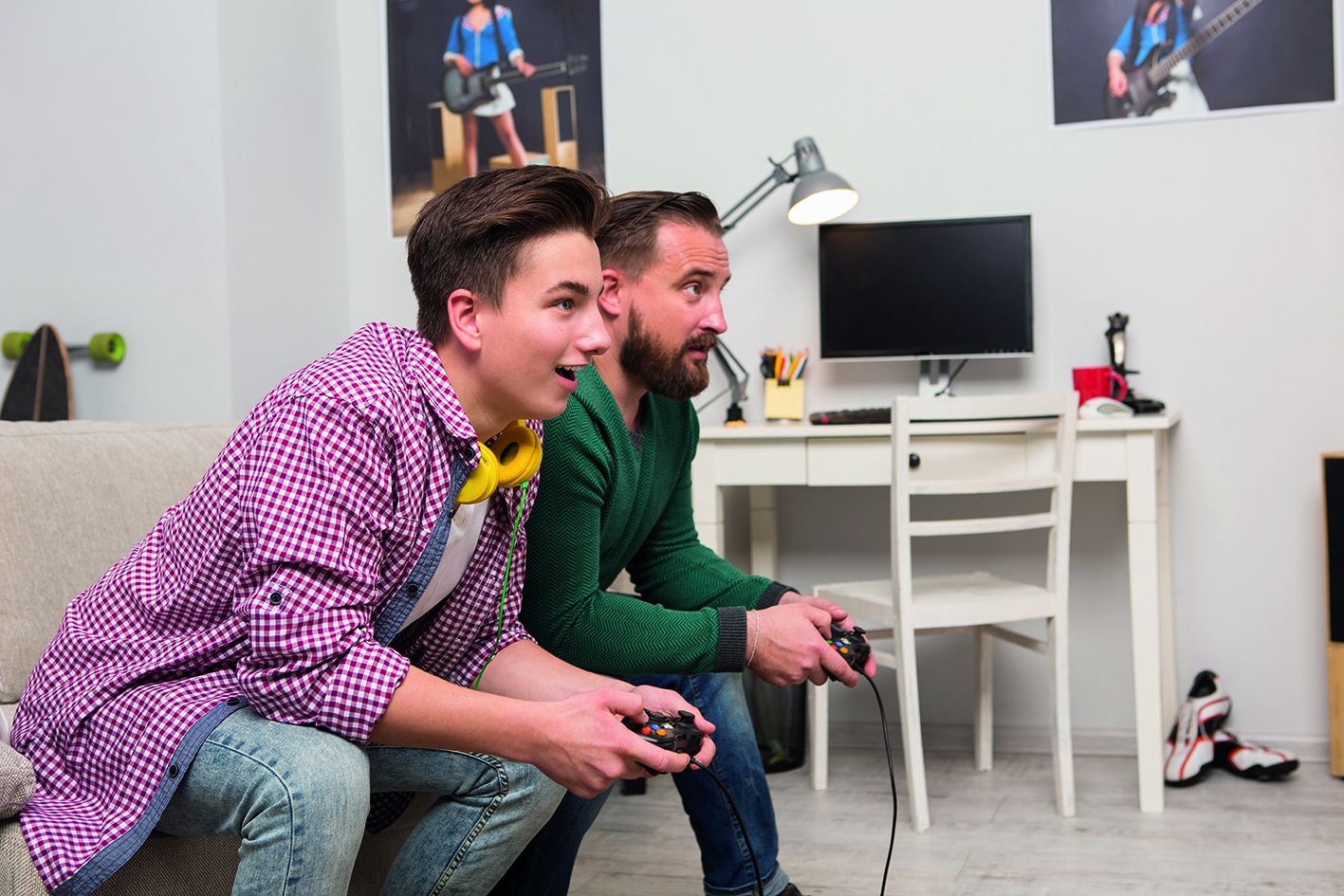 Teen boy playing a computer game with dad
