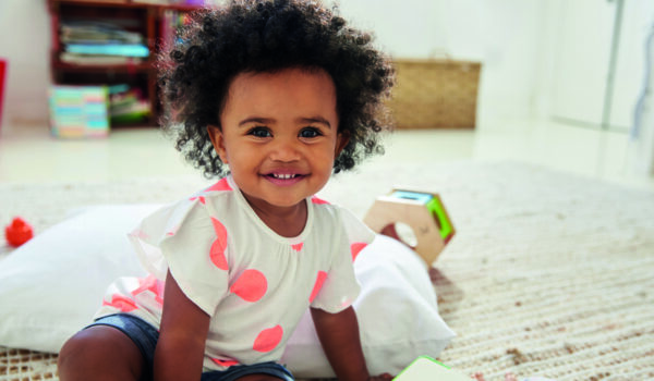 Happy Baby Girl Playing With Toys In Playroom