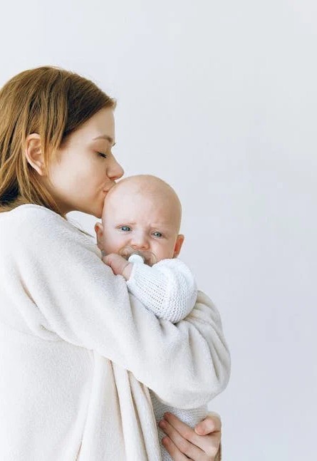 mother kissing baby