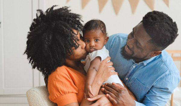 A mum and dad hugging a small child