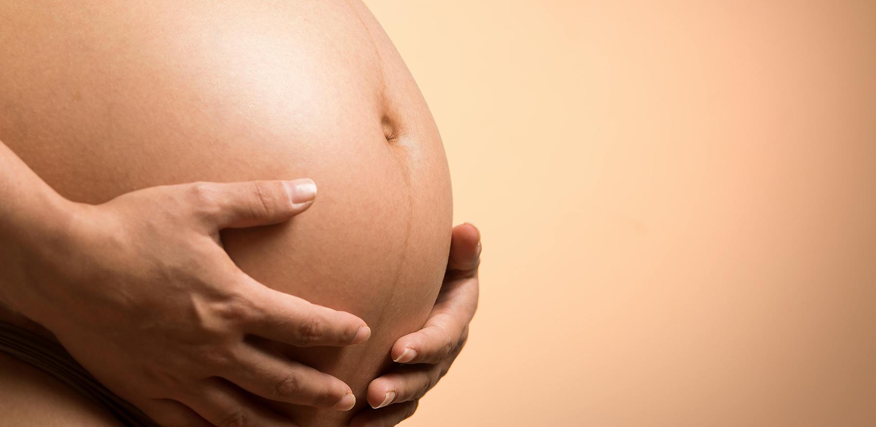 A woman holding her baby bump