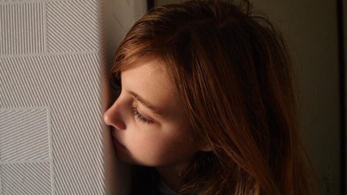 pexels-pixabay-271733 Girl hiding behind a wall