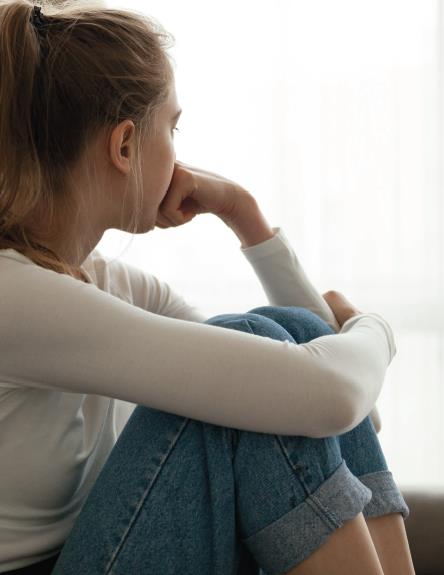 teenage girl looking out of window